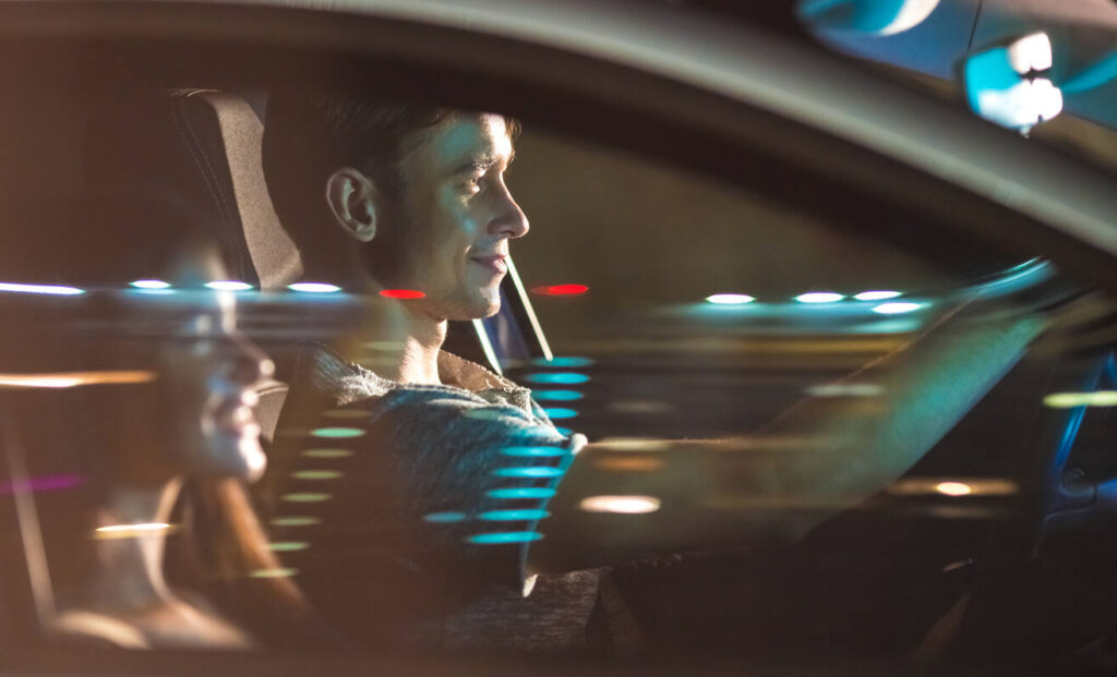 Alt text: "A driver and passenger in a car, highlighting the distraction of engaging in conversation or other activities that can lead to an extra 27 seconds of distracted driving, increasing the risk of accidents.