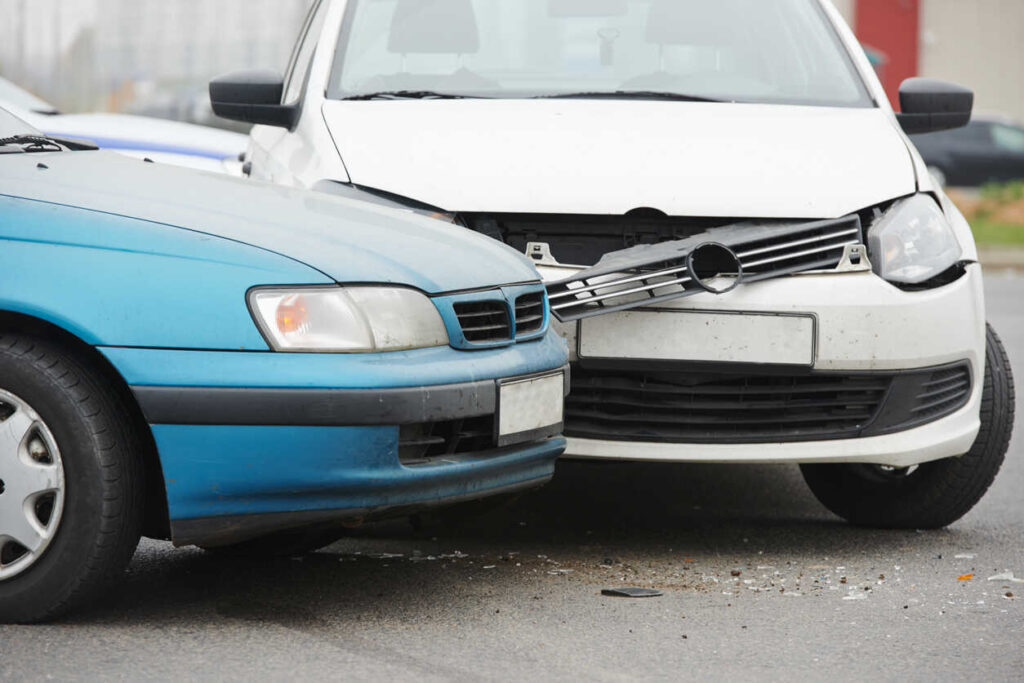 A car crash with visible damage to the front end of two cars, highlighting the importance of understanding who covers a worker’s lost wages after a car accident, such as workers' compensation or insurance claims.