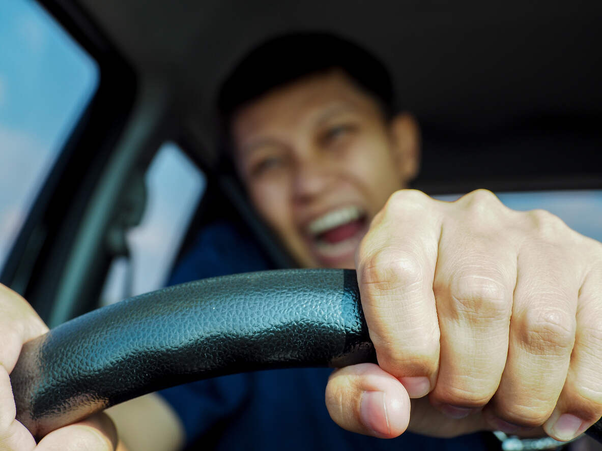 Close-up of hands clenching a steering wheel during a car crash moment, underscoring the dangers of distracted driving and the challenge of proving negligence.
