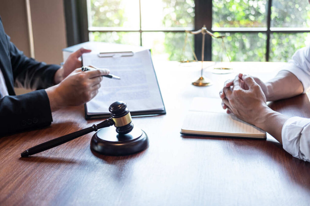 Client and lawyer sitting and discussing personal injury case . lawyer showing documents.