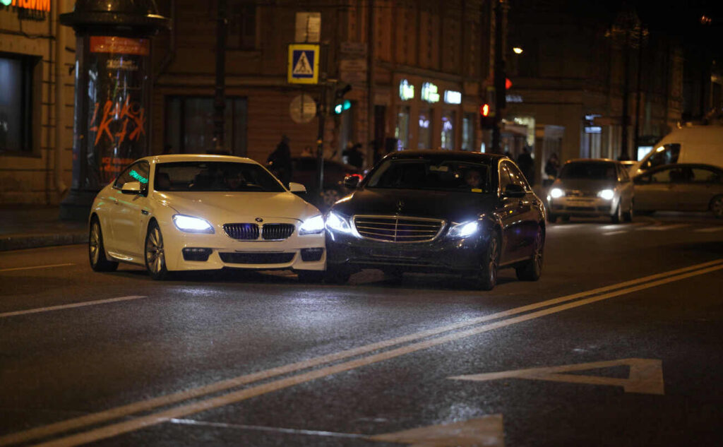 Two cars involved in a minor nighttime car crash on a city street, illustrating how even small collisions in New Hampshire can result in major injury claims.
