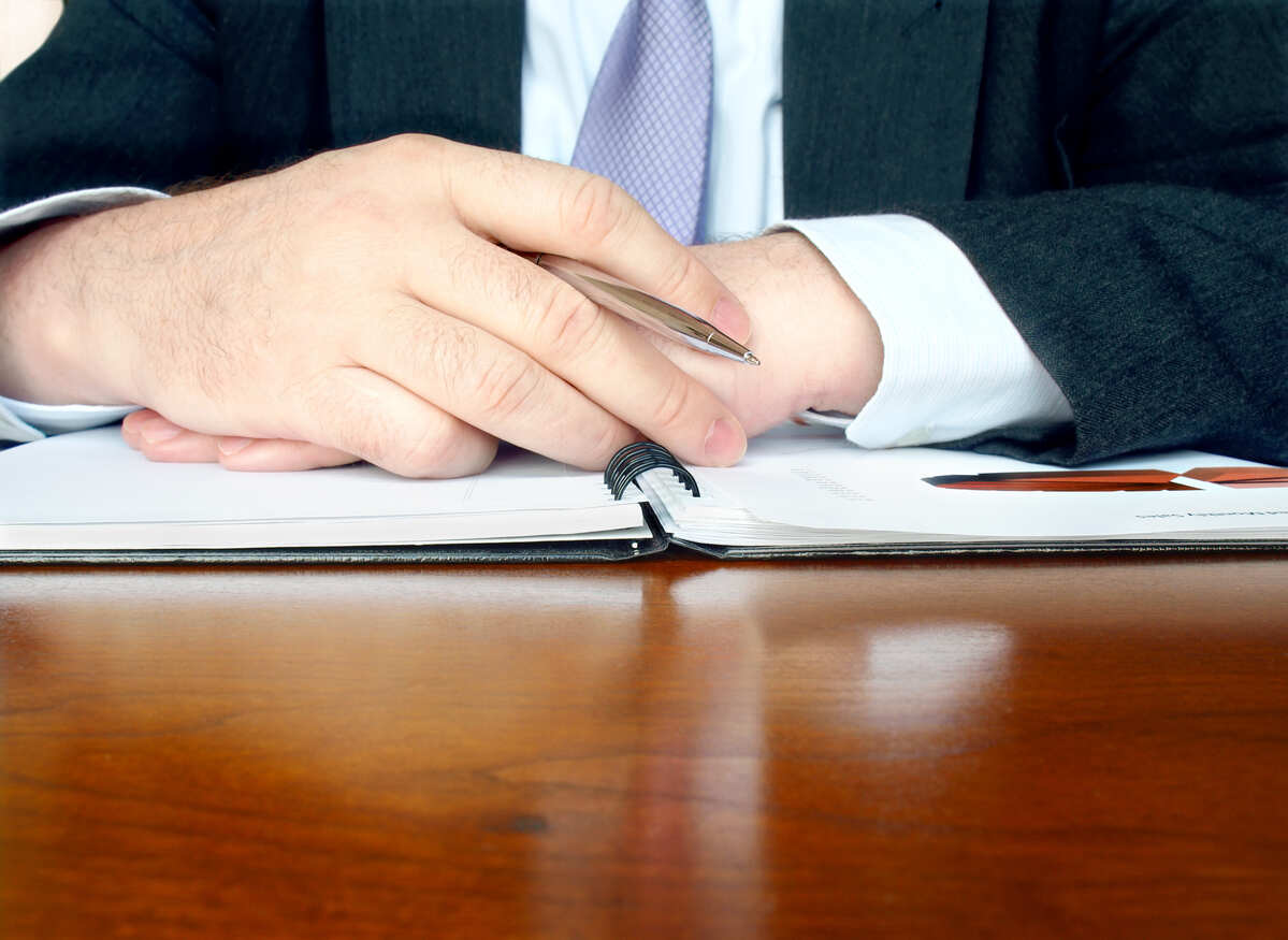 New Hampshire personal injury lawyer reviewing case documents at desk with pen and legal files