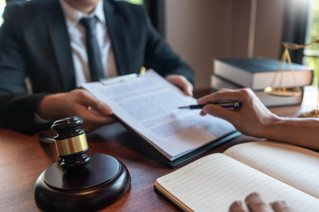 A lawyer actively writing on a document during a legal consultation, representing a personal injury lawyer in Manchester.