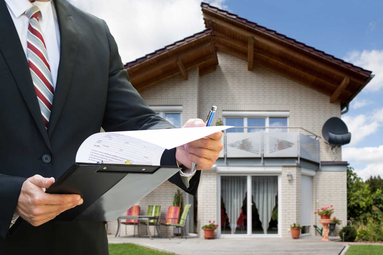 A person in a suit holding a clipboard in front of a house, symbolizing property owner responsibilities and the legal implications of inadequate maintenance.