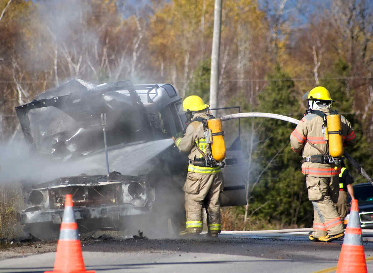 Firefighters extinguish a vehicle fire at the scene of a serious crash, relevant for UM/UIM coverage in NH or MA.